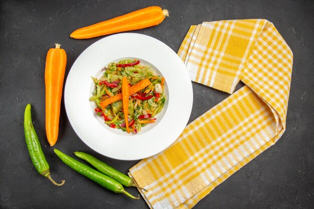 Top close-up view salad plate of salad with vegetables checkered tablecloth hot peppers