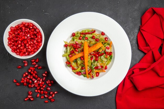 Top close-up view salad vegetable salad seeds of pomegranate red tablecloth