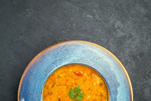 Top close-up view soup an appetizing soup with herbs in the bowl