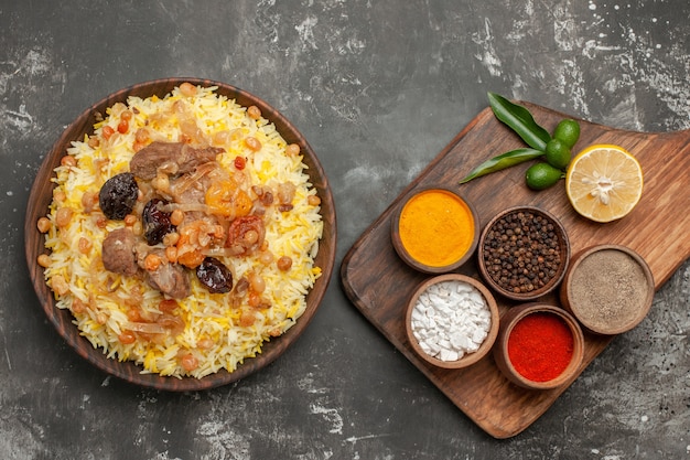 Foto gratuita vista ravvicinata dall'alto condisce un appetitoso pilaf sul tagliere spezie colorate sul tagliere