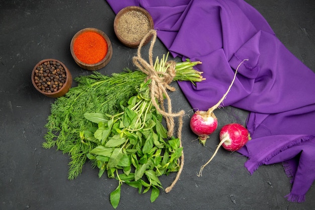 Free photo top close-up view spices three bowls of spices raddish herbs purple tablecloth