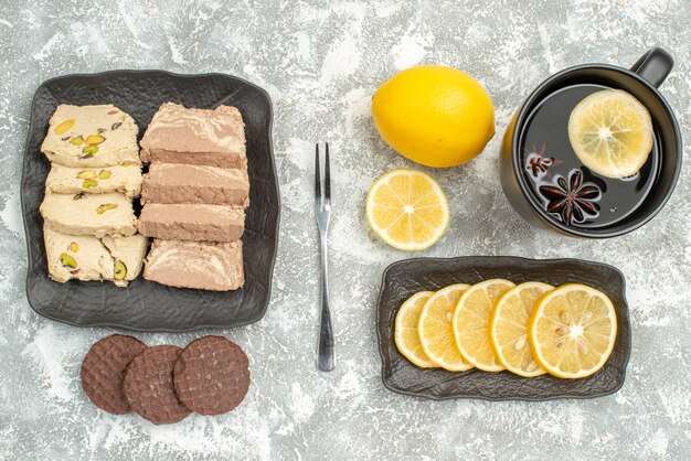 Top close-up view sweets a cup of tea lemon fork cookies sunflower seed halva