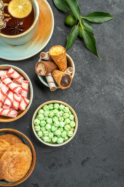 Top close-up view sweets a cup of tea waffles cookies citrus fruits