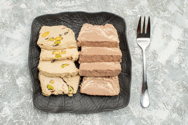 Free photo top close-up view sweets sunflower seed halva on the plate fork