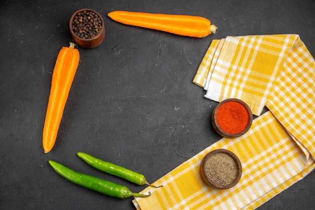 Top close-up view vegetables checkered tablecloth carrots hot peppers spices