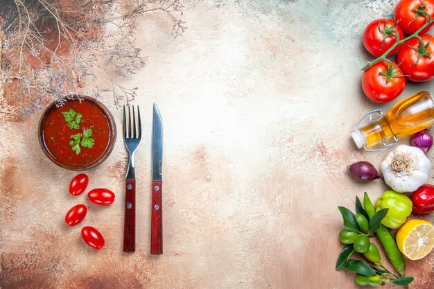 Top close-up view vegetables colorful vegetables sauce fork knife on the table