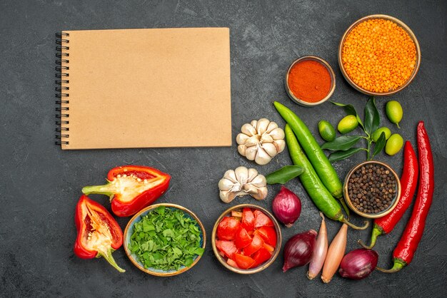 Top close-up view vegetables herbs spices peppers tomatoes lentil cream notebook