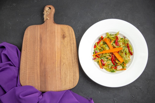 紫色のテーブルクロスの横にあるまな板の上のクローズアップビュー野菜サラダ