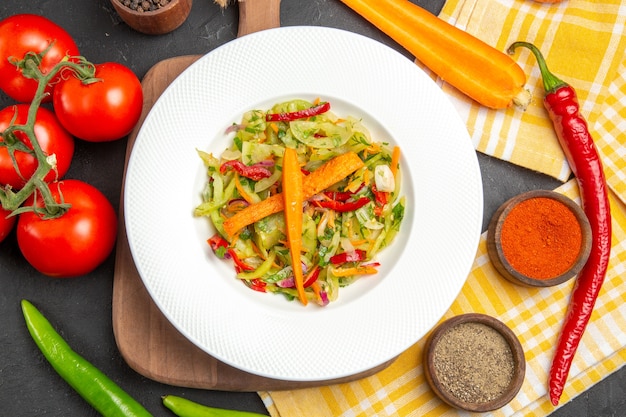 Верхний вид крупным планом овощи, специи, овощной салат на скатерти на разделочной доске