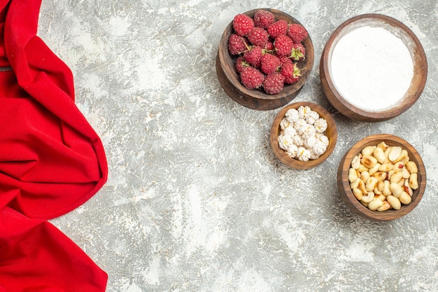 Top close view of bowls of healthy snacks with a red napkin on the side on a marble backgorund