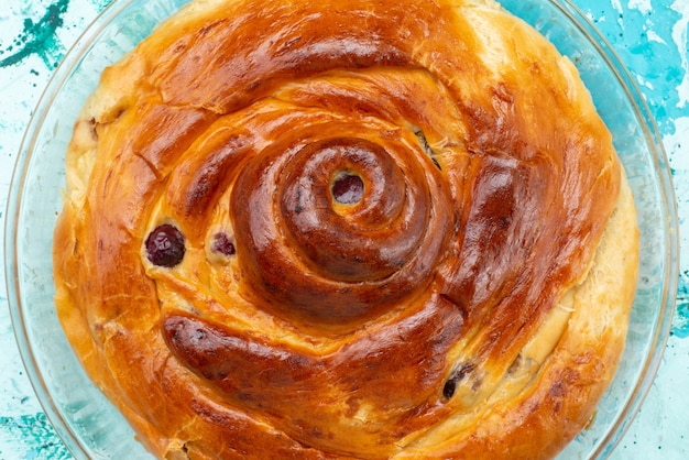 Сверху крупным планом вишневый пирог, запеченный с вишней внутри на голубом пироге из сладкого сахара