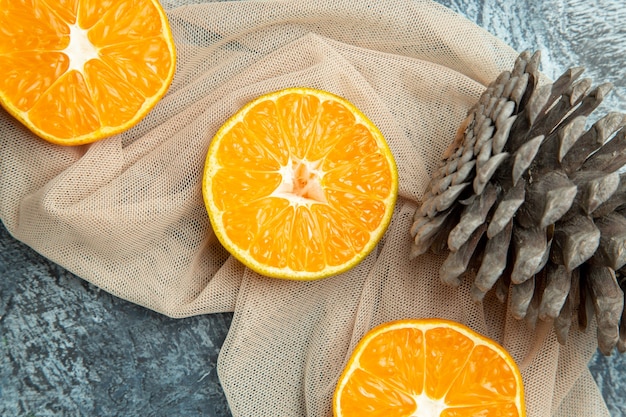 무료 사진 상위 뷰 닫기 어두운 표면에 베이지 색 목도리에 오렌지 솔방울을 잘라