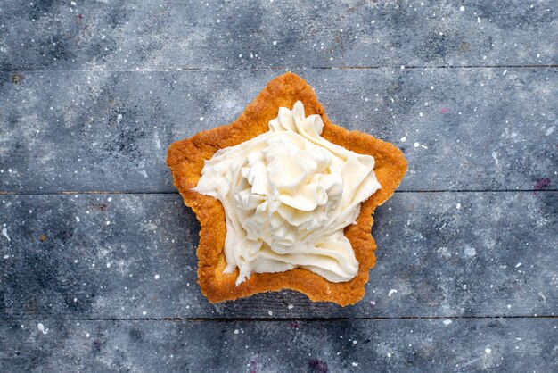 Top close view of delicious baked cake star shaped with white yummy cream inside on light desk, cake bake sugar sweet cream tea