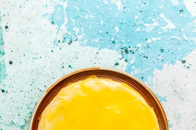 Free photo top close view delicious cake with yellow syrup on blue surface