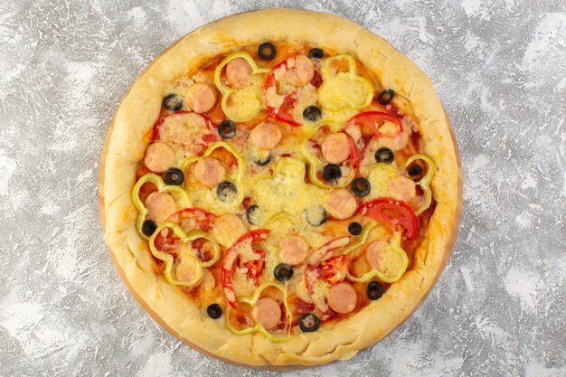 Top close view delicious cheesy pizza with olives sausages and tomatoes on the grey background fast-food italian dough food meal