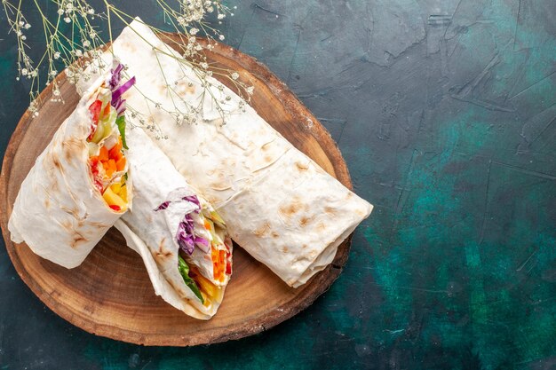 Foto gratuita top vista ravvicinata delizioso panino di carne fatto di carne alla griglia allo spiedo affettato sulla scrivania blu