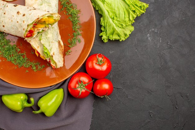 어두운 공간에 신선한 야채와 함께 상위 뷰 닫기 맛있는 슬라이스 shaurma 샌드위치