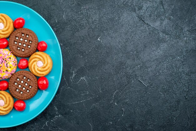 Top close view different sugar cookies inside plate on a grey background candy sugar sweet tea cookies biscuit