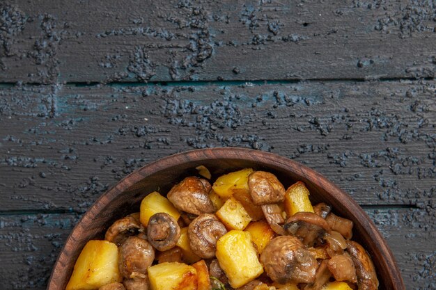 Top close view food on the table brown bowl with potatoes and mushrooms at the bottom of the table