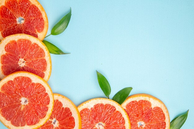 Top close view fresh grapefruits fruit slices on blue background