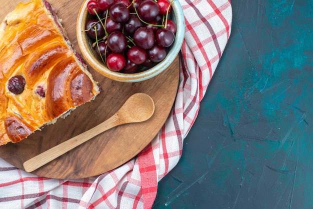 Top close view of fresh sour cherries with cherry cake on dark-blue, pie cake fruit cherry sweet