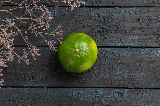 Free photo top close view lime on the table green lime in the center of grey table