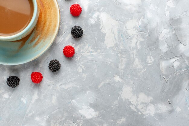 Top close view of milk coffee with confiture berries on white