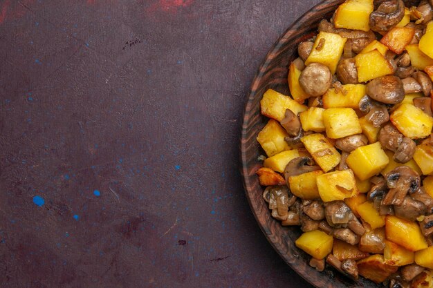 Top close view mushrooms and potatoes fried potatoes and mushrooms in a bowl on a dark background