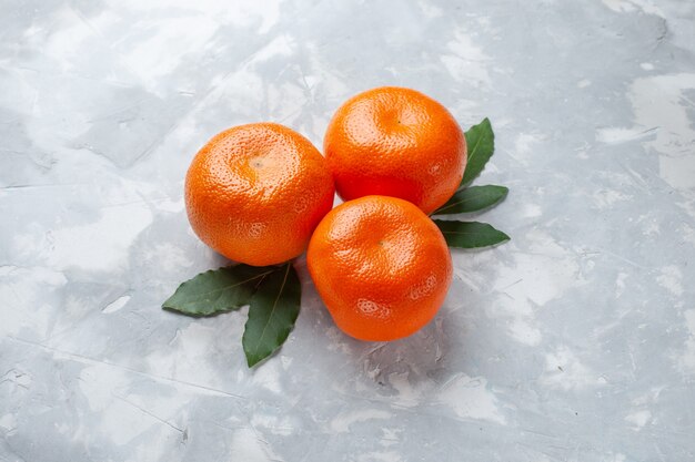 Top close view orange tangerines whole citruses on light desk citrus exotic juice fruit