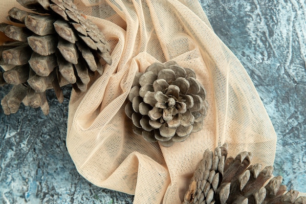 Free photo top close view pinecones on beige shawl on dark surface