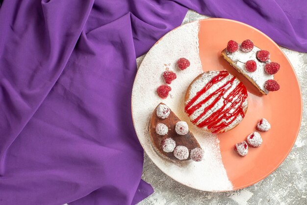 Top close view of plate of dessert on purple napkin with free place for your text on marble background