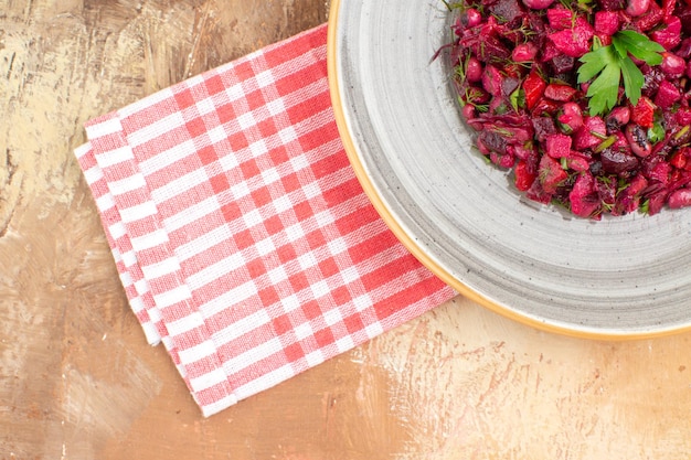 Free photo top close view of plate of a red salad on a wooden backgorund