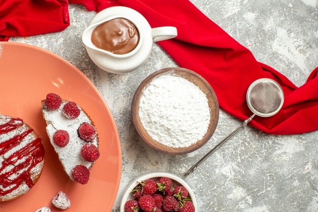 Top close view of plate of sweet dessert with chocolate tea sieve berries and red napkin on side on marble background