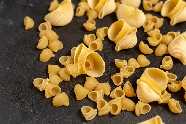 Top close view of raw italian pasta on the dark surface