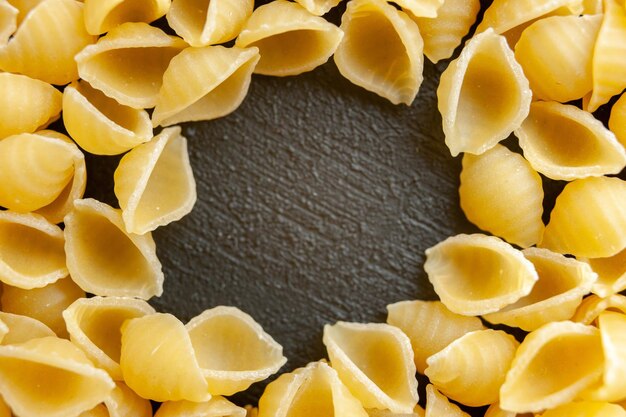 Top close view raw italian pasta on gray background color pasta italy food photo dough many