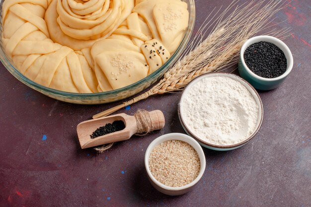 Top close view raw pie round formed with seasonings on purple desk