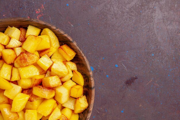 Top close view sliced potatoes inside brown plate on dark space