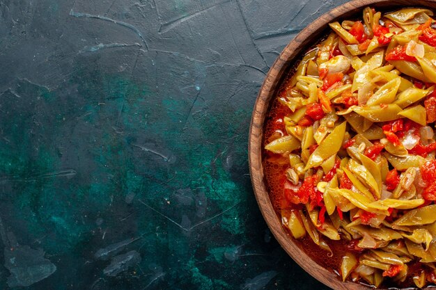 Top close view sliced vegetable meal cooked with different ingredients on dark-blue surface