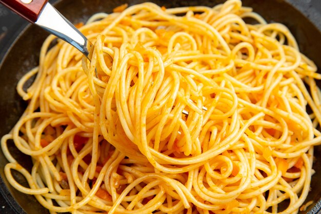 Top close view spaghetti frying pan on dark surface