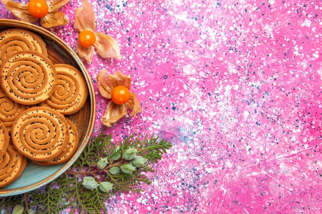 Top close view sweet cookies delicious little cookies with physalises on light-pink desk.