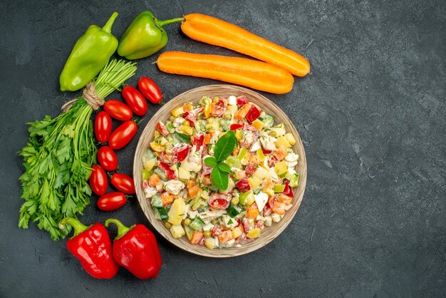 Top close view of veggie salad with vegetables on dark grey background