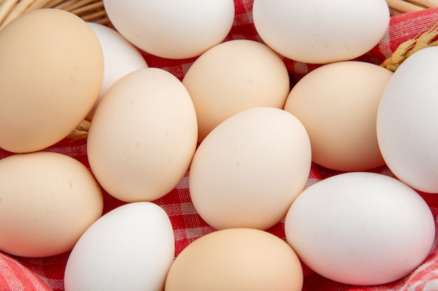 Top close view white chicken eggs inside basket with towel