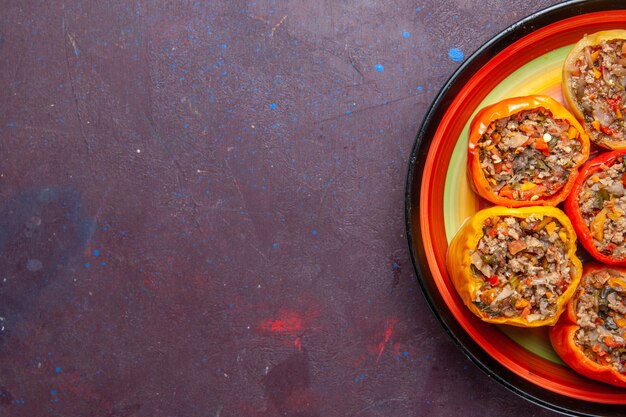 Top closer view cooked bell-peppers with ground meat on dark grey background food beef dolma vegetables meal