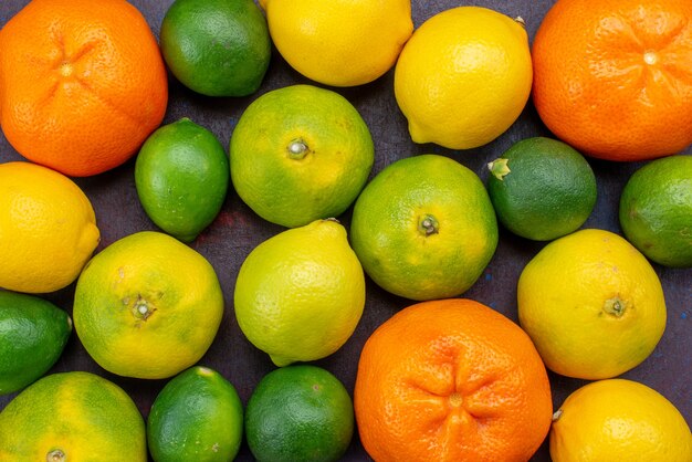 暗い机の上で他の柑橘類で着色された新鮮なジューシーなみかんオレンジを上から見る柑橘類の熱帯のエキゾチックなオレンジ色の果実