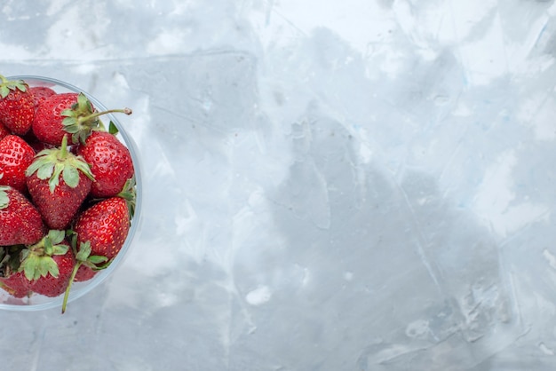 가벼운 책상에 유리 접시 안에 신선한 빨간 딸기 부드러운 여름 딸기의 상위 가까이보기