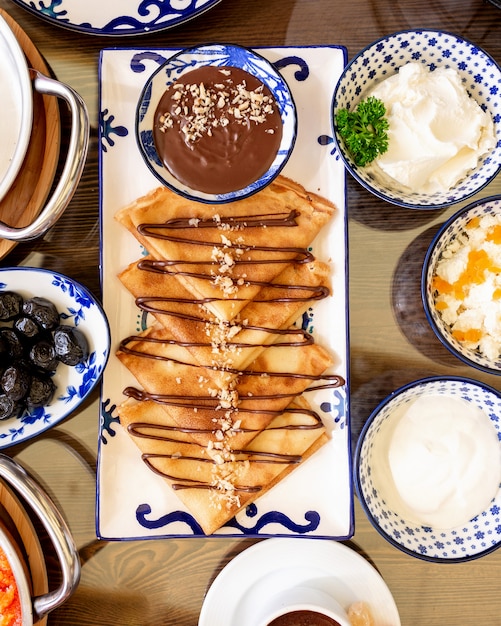 top  crepes with with chocolate cream and nuts on platter