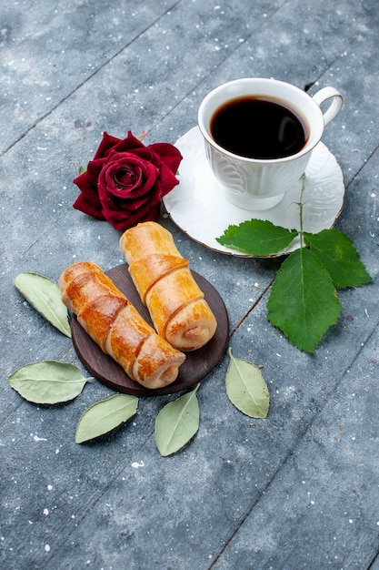 Бесплатное фото Чашка кофе с видом сверху и сладкие вкусные браслеты на сером