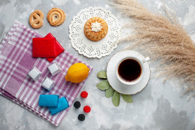 光の上のケーキレモンチョコレートと白いカップの中で熱いお茶のトップ遠景カップ