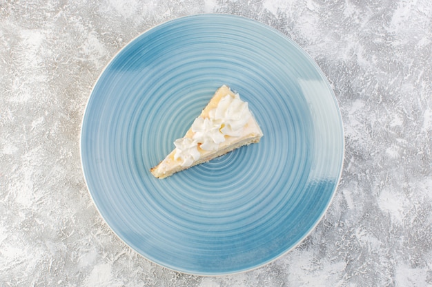 灰色の背景のビスケットケーキティー甘いクリームに青い丸皿の内側の遠景おいしいケーキスライス