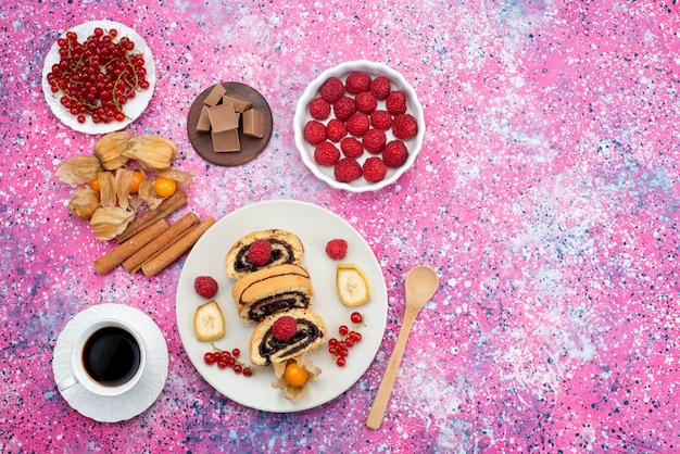 Сверху вдалеке кусочки торта с разными фруктами внутри белой тарелки с кофе и шоколадными батончиками на цветном письменном торте, печенье, сладкие фрукты